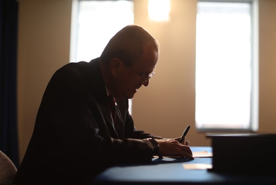photo: Governor Murphy seating behing desk, writing